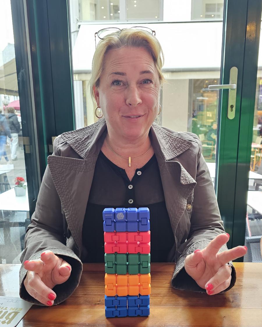Frau staunt über einen hohen Turm aus bunten CUBYs