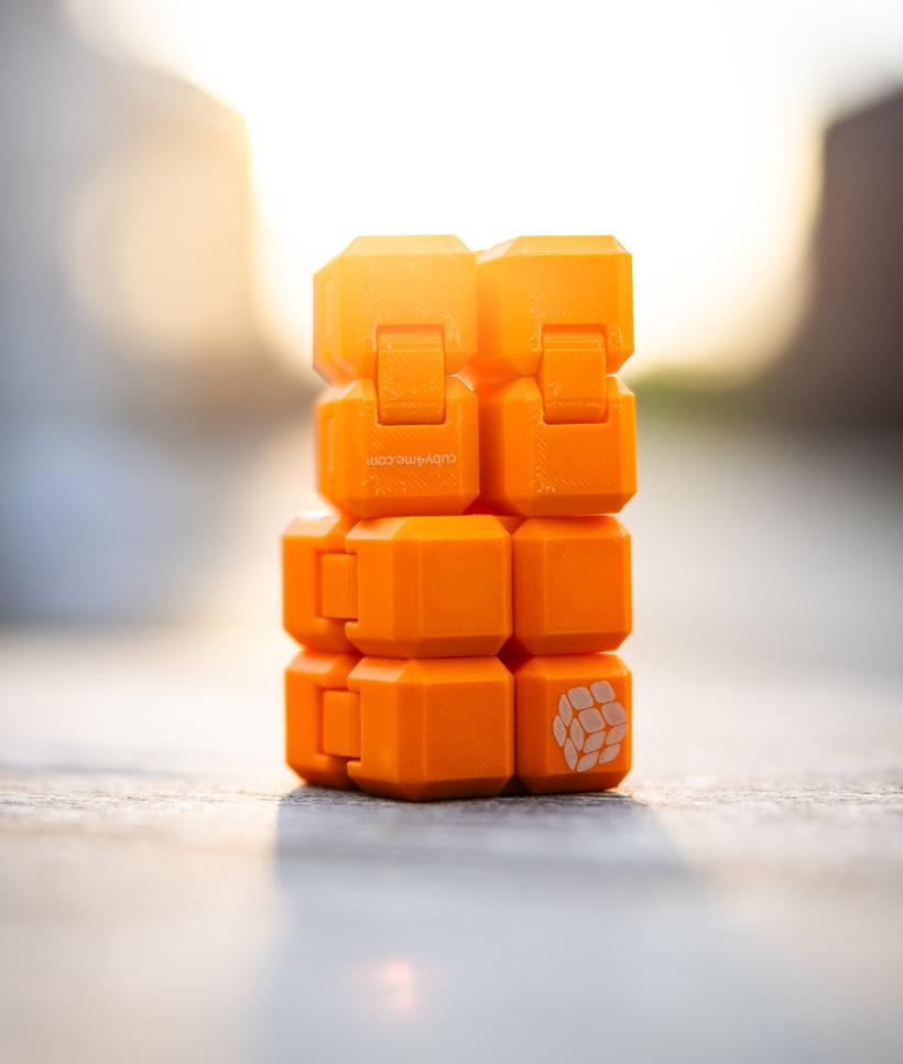 Oranger CUBY-Turm im weichen Abendlicht mit cuby4me.com-Logo